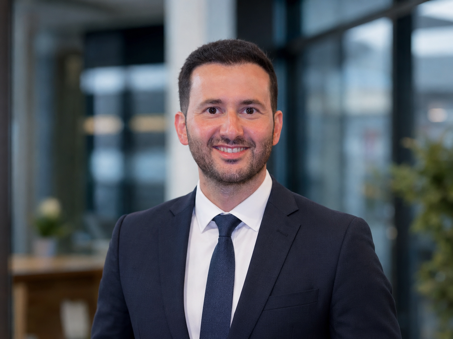 Umut Gül in a dark business suit and tie